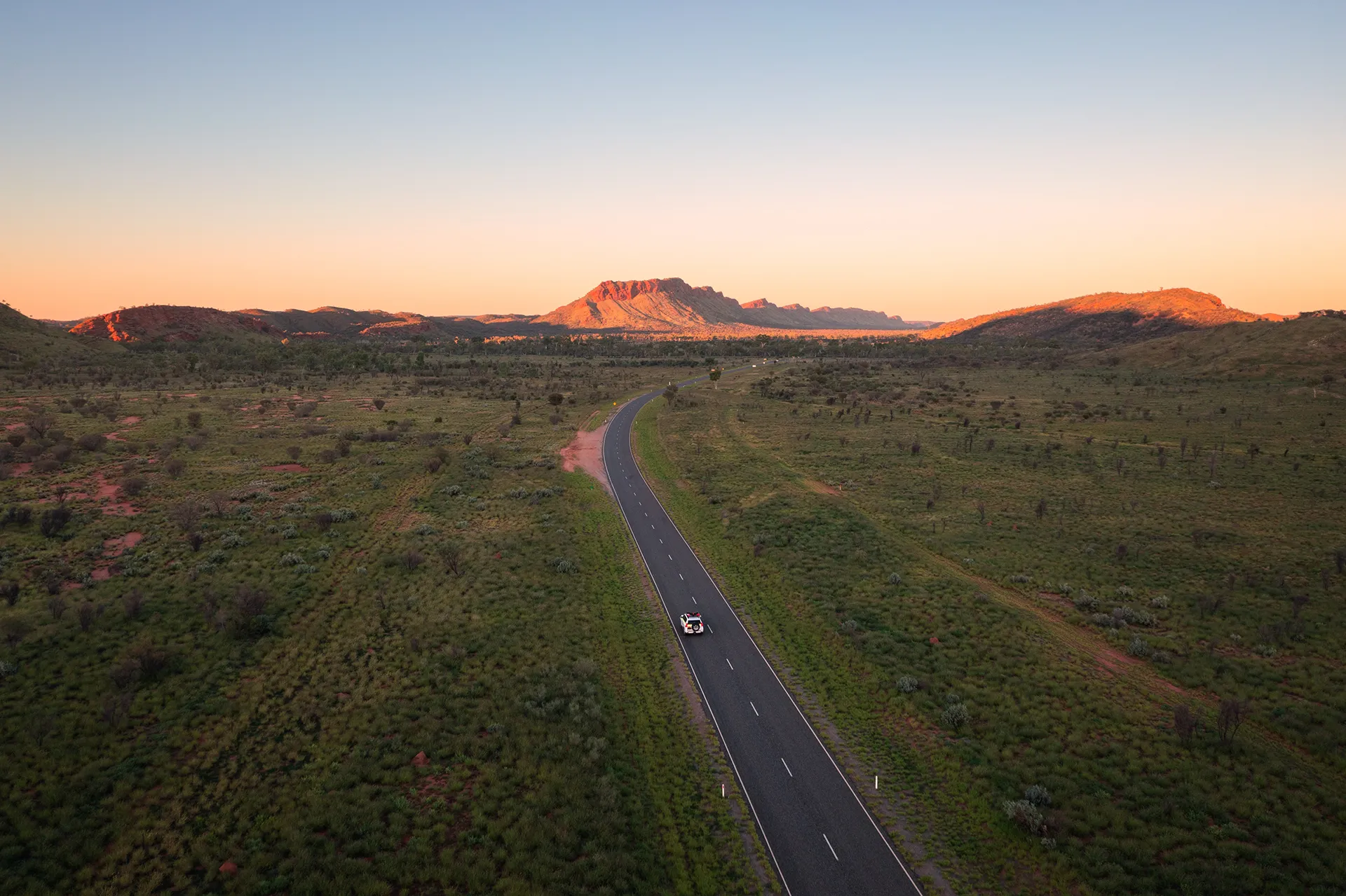 Cruise ship on a calm ocean with a bright orange and yellow sunset